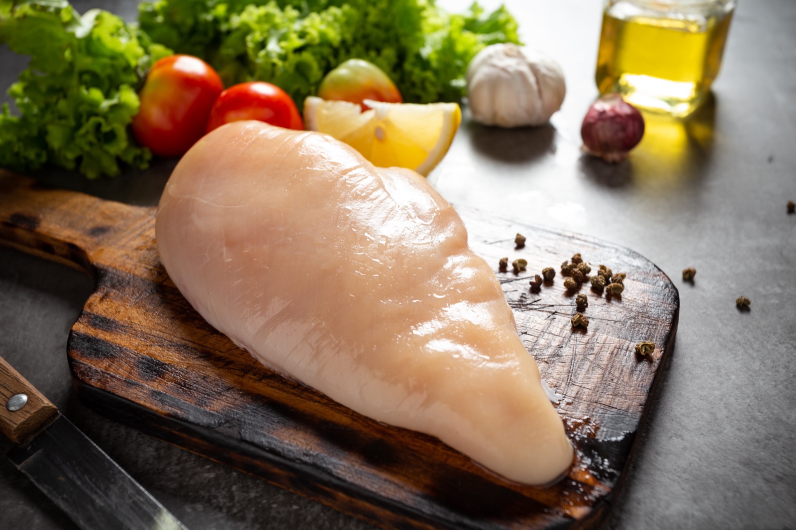 Raw chicken breasts on wooden cutting board